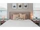 Elegant bedroom with a decorative pillow on bed, two windows, bedside lamps and nightstands at 2052 Milkweed St, Ocoee, FL 34761