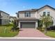 Charming two-story home boasts a well-manicured lawn, brick driveway, and inviting curb appeal in a desirable neighborhood at 2052 Milkweed St, Ocoee, FL 34761