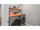 Functional laundry room with wooden countertops and storage, complemented by modern washer and dryer at 2052 Milkweed St, Ocoee, FL 34761