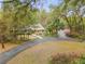 A beautiful home exterior featuring lush landscaping, a metal roof, and a circular driveway at 2180 Lauren Ln, Deland, FL 32720