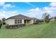 Back exterior view featuring the house, a sprawling green lawn, and manicured landscaping at 2282 Kaley Ridge Rd, Clermont, FL 34715