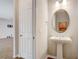 Powder room featuring pedestal sink with a round mirror and decorative lighting at 2282 Kaley Ridge Rd, Clermont, FL 34715
