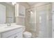 All-white bathroom featuring a glass-enclosed shower, vanity with sink, and mirrored cabinet at 2282 Kaley Ridge Rd, Clermont, FL 34715