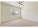 Cozy bedroom with neutral carpet, a ceiling fan, and a window for natural light at 2282 Kaley Ridge Rd, Clermont, FL 34715