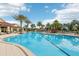 Expansive community pool surrounded by palm trees, lounge chairs, and a poolside pavilion at 2282 Kaley Ridge Rd, Clermont, FL 34715