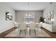 Bright dining room with stylish chandelier, white table and chairs, artwork and plants at 2282 Kaley Ridge Rd, Clermont, FL 34715
