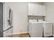 Practical laundry room features modern appliances, overhead cabinets, and a stainless steel refrigerator at 2282 Kaley Ridge Rd, Clermont, FL 34715