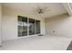 Covered patio features concrete flooring, neutral stucco walls, sliding glass doors, and a ceiling fan at 2282 Kaley Ridge Rd, Clermont, FL 34715