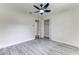 Bedroom with closet, grey floors, neutral paint, ceiling fan, and a door leading to another room at 2341 Sw 11Th Ave, Ocala, FL 34471