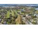 High angle view of a golf course surrounded by homes and a lake, highlighting its recreational amenities at 26 Backspin Ln, Orlando, FL 32804