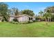 Charming home featuring lush landscaping, mature trees and a convenient covered carport at 26 Backspin Ln, Orlando, FL 32804
