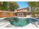 Backyard with a large in-ground pool surrounded by lush tropical landscaping at 26 Backspin Ln, Orlando, FL 32804