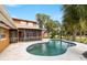 Backyard featuring an in-ground pool, screened lanai, and tropical landscaping at 26 Backspin Ln, Orlando, FL 32804