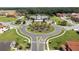 Aerial view of community roundabout with lush landscaping, palm trees and beautiful community center with pool at 2613 Santosh Cv, Kissimmee, FL 34746