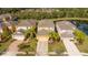 Aerial view of a home featuring mature landscaping in a neighborhood close to a pond at 2613 Santosh Cv, Kissimmee, FL 34746