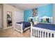 Bright bedroom featuring twin beds, colorful accents, and a calming blue accent wall at 2613 Santosh Cv, Kissimmee, FL 34746