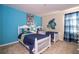 The bedroom is light and airy with two white single beds, bright accents, and a fun mural at 2613 Santosh Cv, Kissimmee, FL 34746
