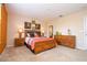 Bright bedroom showcasing a wood bed frame, two dressers, wall art and a full-length mirror at 2613 Santosh Cv, Kissimmee, FL 34746