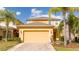 Two-story home with a two-car garage, lush landscaping, and vibrant yellow facade at 2613 Santosh Cv, Kissimmee, FL 34746