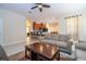 Inviting living room featuring tile flooring, a ceiling fan, and neutral decor flowing into the adjacent kitchen at 2613 Santosh Cv, Kissimmee, FL 34746