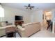 Comfortable living room featuring neutral-toned furniture, tile flooring, and a ceiling fan at 2613 Santosh Cv, Kissimmee, FL 34746