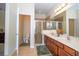 Well-lit main bathroom showcasing double sinks, wooden cabinetry, and a glass-enclosed shower at 2613 Santosh Cv, Kissimmee, FL 34746