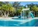 Community pool area featuring a water slide, palm trees, and lounge chairs for residents to enjoy on a sunny day at 2613 Santosh Cv, Kissimmee, FL 34746