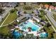 Aerial view of community pool, lounge seating, splashpad and neighborhood homes with lush landscaping at 2613 Santosh Cv, Kissimmee, FL 34746