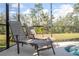 Poolside lounge chairs providing a relaxing view of the pond and natural landscape at 2613 Santosh Cv, Kissimmee, FL 34746