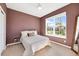 Comfortable bedroom featuring a queen bed, ceiling fan, and natural light from the large window at 2714 Forestdale St, St Cloud, FL 34771