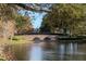 Scenic view of the community pond featuring a stone walking bridge with lush landscaping around the water at 2763 Metro Sevilla Dr # 108, Orlando, FL 32835