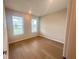 Neutral bedroom with hardwood floors and natural light streaming in from the two windows at 2765 Redblush Ter, St Cloud, FL 34772