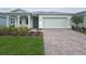 Charming single-story home featuring a brick driveway, landscaped front yard, and a two-car garage at 2765 Redblush Ter, St Cloud, FL 34772