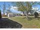 Extensive backyard with mature trees, a storage shed, and a brick walkway at 2801 W Covington Dr, Deltona, FL 32738