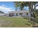 Large backyard featuring a brick patio, storage shed, and mature trees at 2801 W Covington Dr, Deltona, FL 32738