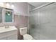 A compact bathroom featuring a sink, toilet and shower with marble wall paneling and sliding glass doors at 2801 W Covington Dr, Deltona, FL 32738