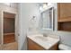 A bathroom features a wood vanity, light blue walls, and a framed mirror with three-bulb lighting above at 2801 W Covington Dr, Deltona, FL 32738
