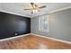 This bedroom features a dark accent wall, wood flooring, and a window at 2801 W Covington Dr, Deltona, FL 32738