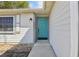 Close-up of a charming front door with a teal finish, complemented by white siding and a decorative light fixture at 2801 W Covington Dr, Deltona, FL 32738