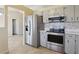 Functional kitchen featuring stainless steel appliances, light gray cabinets, and a pantry door for organized storage at 2801 W Covington Dr, Deltona, FL 32738