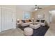 Cozy living room with neutral tones, featuring comfortable seating, a ceiling fan, and ample natural light at 2801 W Covington Dr, Deltona, FL 32738