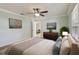 A tranquil main bedroom featuring light-green walls, light-colored hardwood floors, and a ceiling fan at 2801 W Covington Dr, Deltona, FL 32738