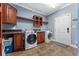 A convenient laundry room featuring modern washer, dryer, storage, and tile floors at 36010 Kalamazoo Dr, Eustis, FL 32736