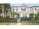 Charming two-story townhouse featuring a black metal fence, lush landscaping, and a welcoming front entrance at 4527 Sunset Ln, Oviedo, FL 32765