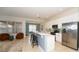 Open-concept kitchen with white cabinets, stainless steel appliances, quartz countertops, and a breakfast bar at 4527 Sunset Ln, Oviedo, FL 32765