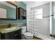 Bathroom featuring a glass block shower, vessel sink, and storage cabinet at 501 Sheridan Blvd, Orlando, FL 32804