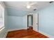 Bedroom with hardwood floors, a ceiling fan, blue walls, and a view to another room at 501 Sheridan Blvd, Orlando, FL 32804