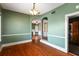 View of the dining room boasting hardwood floors, arched doorways, and a unique lighting fixture at 501 Sheridan Blvd, Orlando, FL 32804