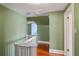 Hallway with hardwood floors, green textured walls, white trim, and view to another room at 501 Sheridan Blvd, Orlando, FL 32804