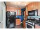 Well-equipped kitchen featuring wood cabinets, a gas range, and black appliances at 501 Sheridan Blvd, Orlando, FL 32804